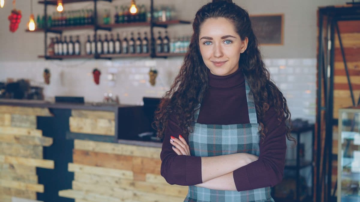 Café owner standing confidently in front of her counter